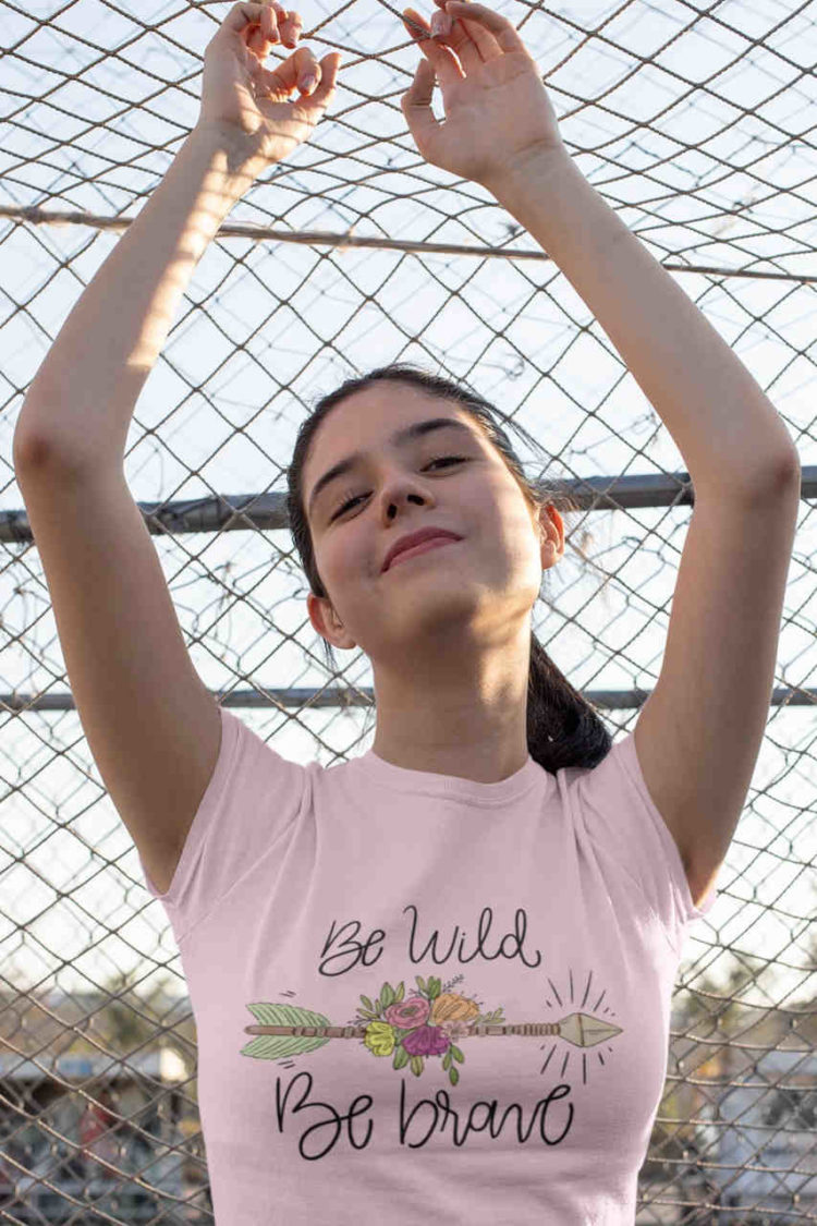 confident girl in light pink Be Wild Be Brave tshirt