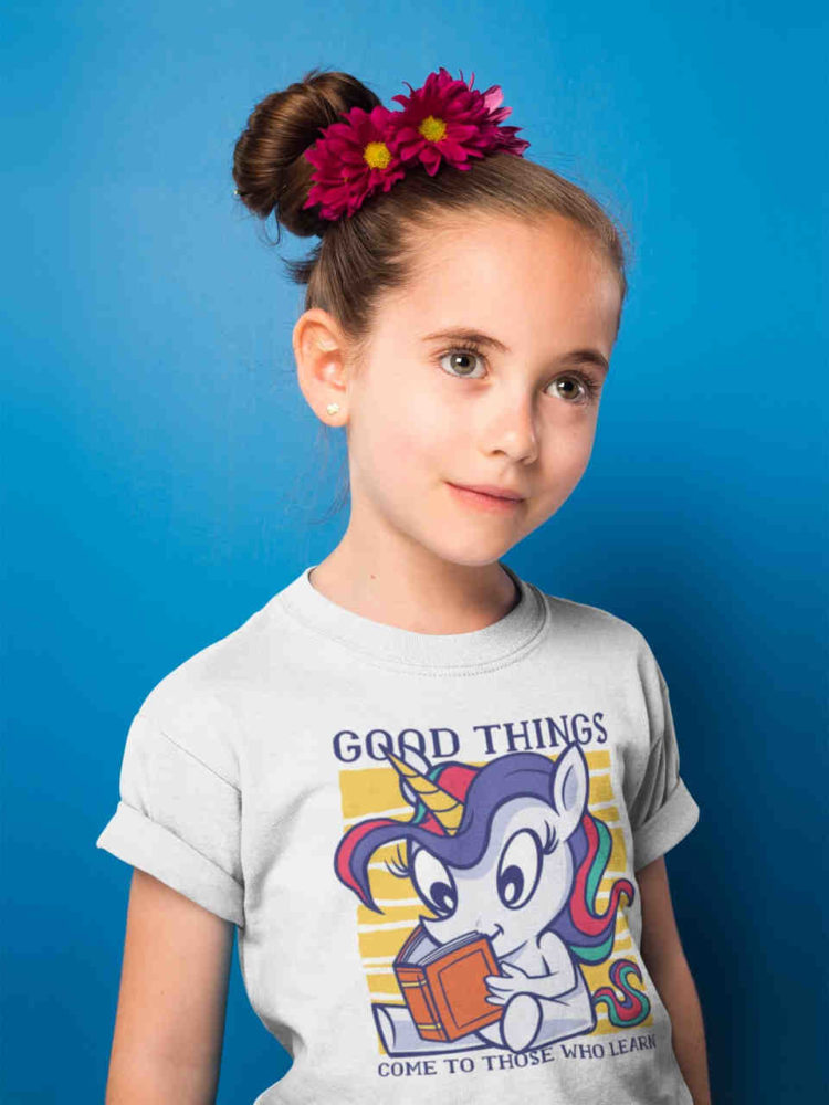 cute girl in white tshirt with Unicorn reading a book