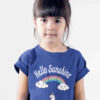 sweet girl in deep blue tshirt with unicorn swinging on a rainbow