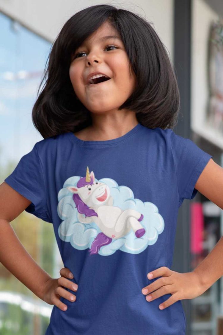 happy girl in deep blue tshirt with Unicorn lying on a cloud