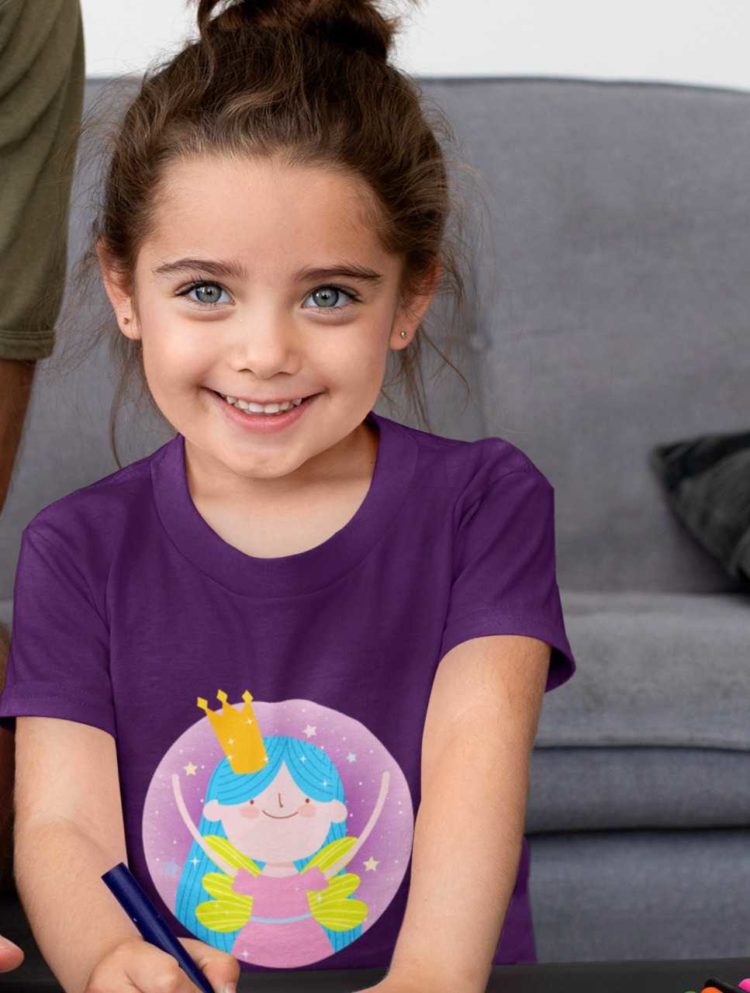 happy little girl in a purple tshirt with a fairy wearing a crown