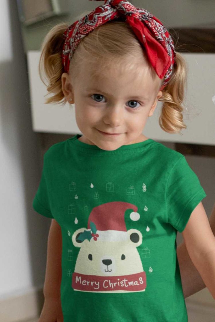 cute girl in a green tshirt with a Bear in a santa hat