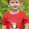 Cute boy in a Red tshirt with a penguin inside a snow globe