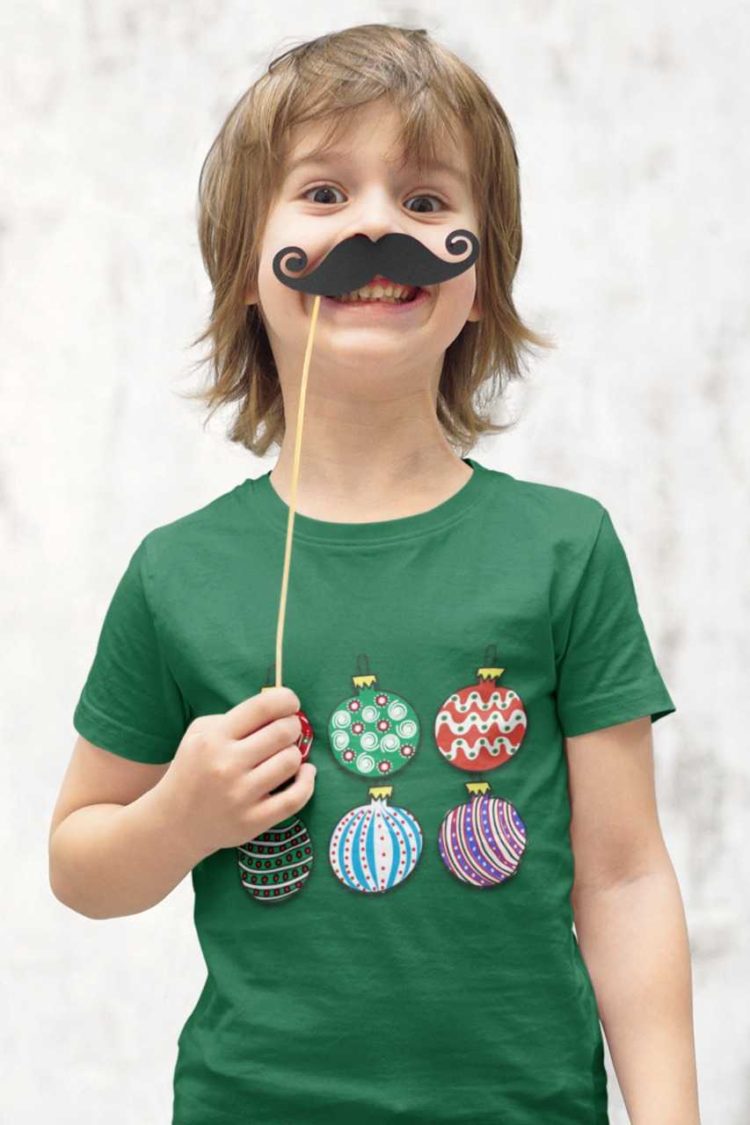 playful boy in a green tshirt with Christmas ornaments