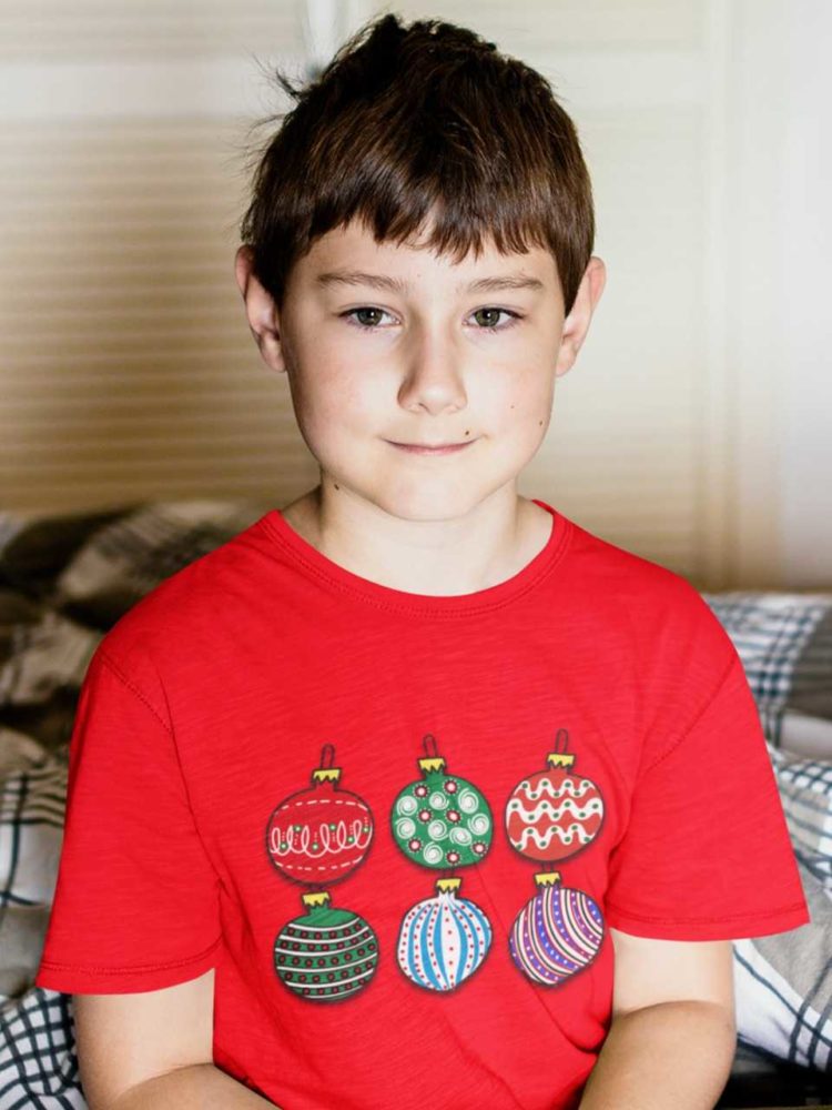 sweet boy in a red tshirt with Christmas ornaments