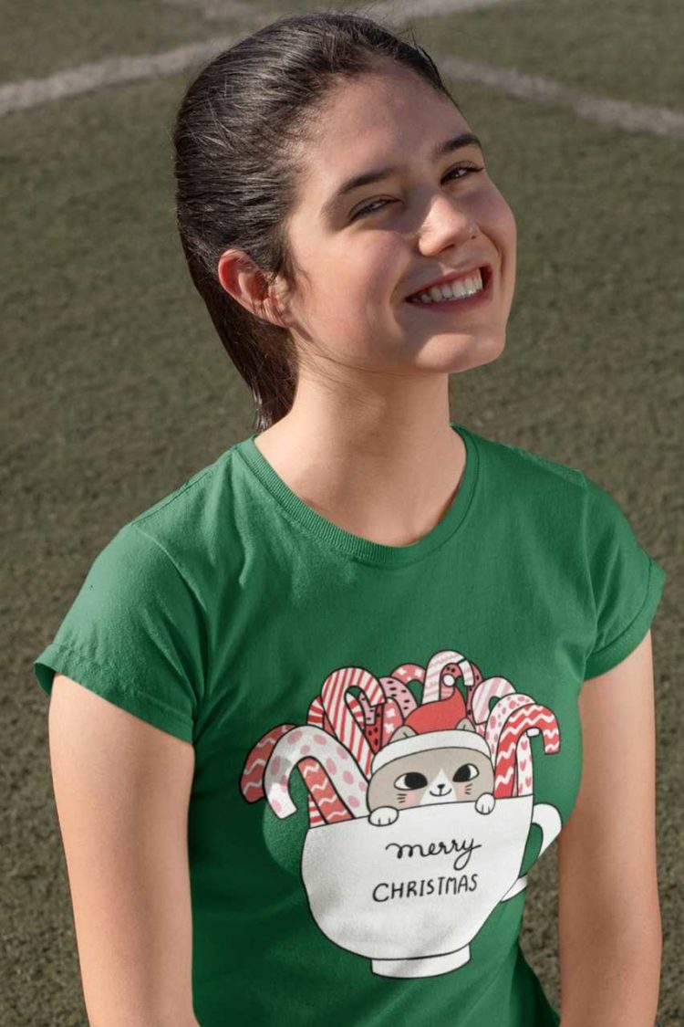 happy girl in a green tshirt with Cats in a mug with candy canes