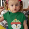 cute girl in a Green tshirt with penguin christmas ornament