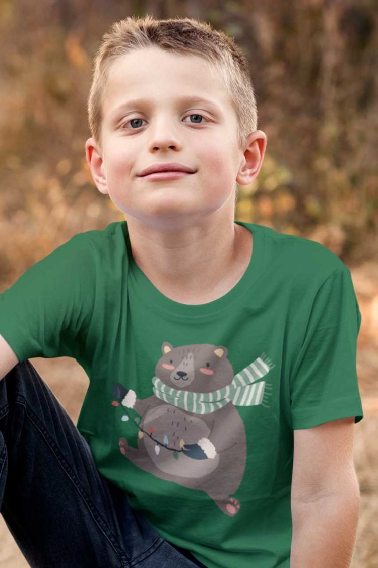 Smart boy in a green tshirt with a Bear holding christmas lights