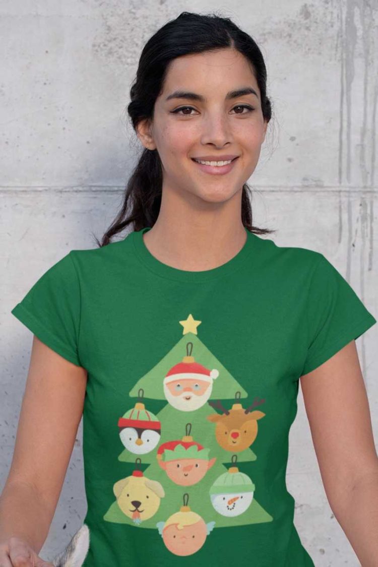 pretty girl in a green tshirt with a christmas tree with character ornaments