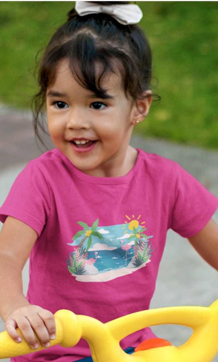 little girl in a dark pink tshirt with Flamingoes on a beach