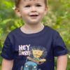 adorable little boy in a navy blue tshirt with Lion driving saying Hey there!