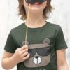 cheerful boy in an olivr green Tshirt with a bear wearing sunglasses