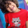 little boy smiling in a red Tshirt with a cute raccoon riding a scooter